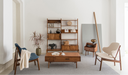 Living room setup featuring elegant Mid Century Furniture including a wooden coffee table, shelving unit, and stylish chairs