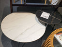 Round marble coffee table with a smaller black and gold table in a room setting.