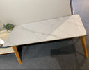 White marble-patterned table with wooden legs on a gray floor.