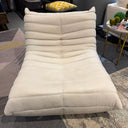White lounge chair in a room with a rug and furniture