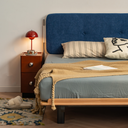 Born in Colour bedframe with blue upholstered headboard and wooden frame in modern bedroom setting