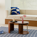 Born in Colour wooden coffee table with curved design on blue patterned rug in modern living room