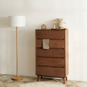 Born in Colour wooden cabinet with four drawers in a minimalist room next to a tall floor lamp
